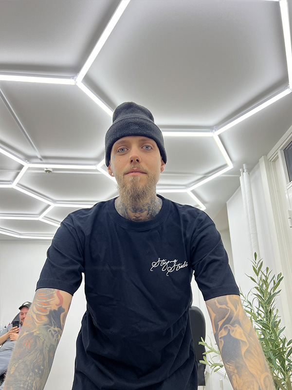 Billede af tattoo artist Lukas "Plov" der kigger mod kameraet.